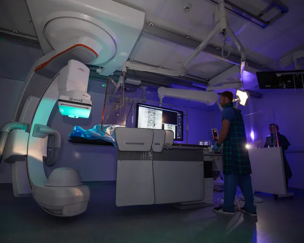 An individual standing in front of a huge mechanical device.