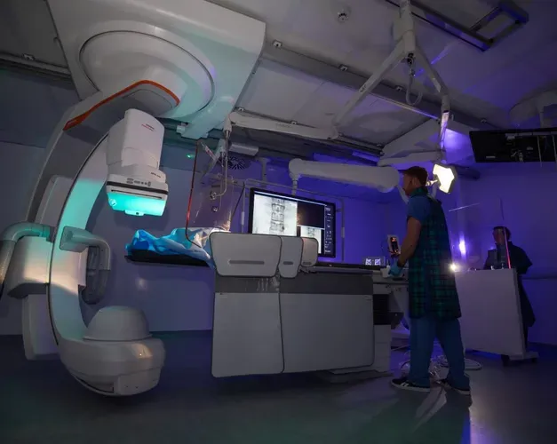 An individual standing in front of a huge mechanical device.