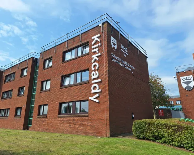 New signage at Kirkcaldy campus. The sign spells outs "Kirkcaldy" in vertical letters going down the side of a red-brick accomodation block