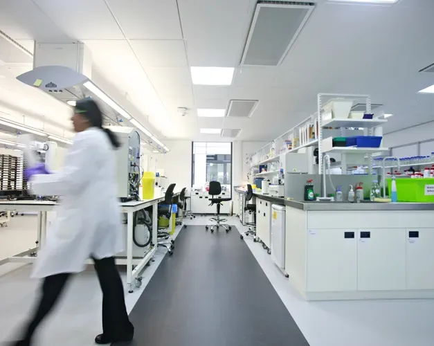 inside a science lab, blurred image of person walking across 