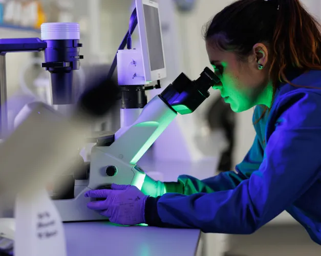 woman looking into microscope
