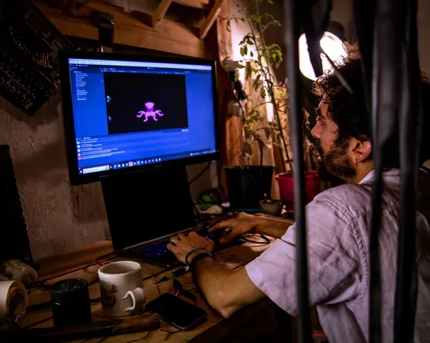 Man in white short sleeved shirt on a desktop computer