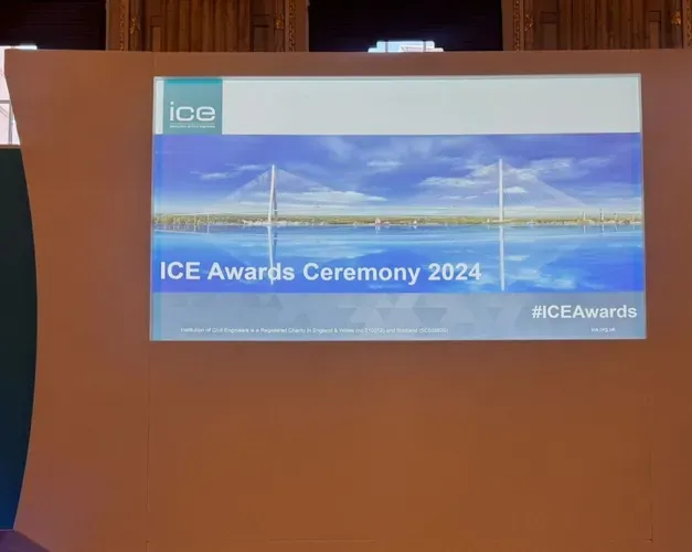 close up on a brown stage backdrop with a landscape poster on it stating ICE Awards 2024