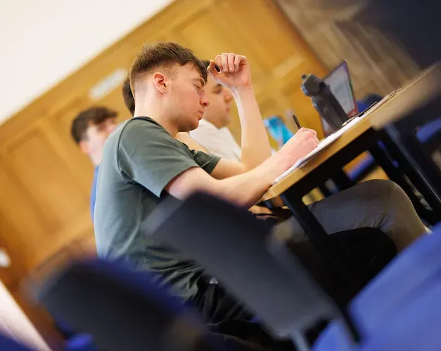 A student taking notes in a lecture