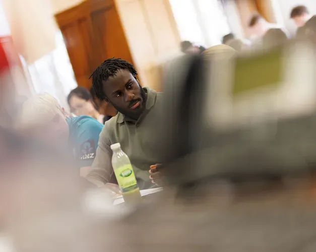 A student looking towards another student sitting in a lecture theatre