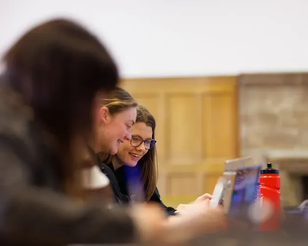 Two students looking at a laptop screen