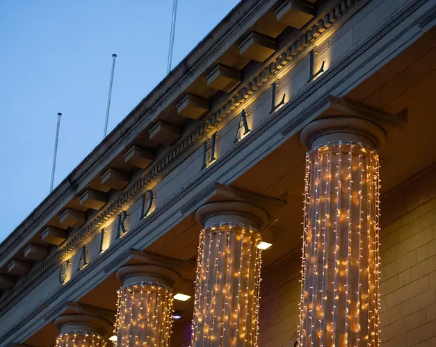 A shot of Caird Hall at dusk, with its name surrounded by winter lights