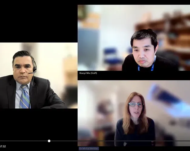 A screenshot of a webinar, three people are tiled together over the screen and a list of smaller tiles with initials sits down the right side of the screen.