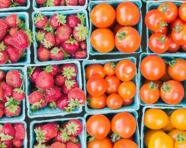 An overhead view of punnets of strawberries and tomatoes