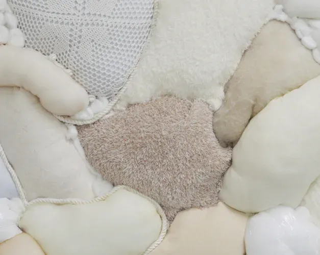 Detail from a tactile artwork by Leah MacMillan featuring different fabrics and textiles, representing an arial view of fields