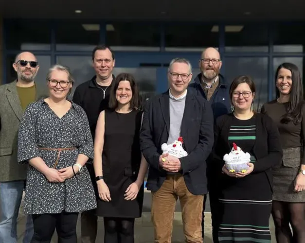 A group of people stand outside a building in the entryway.