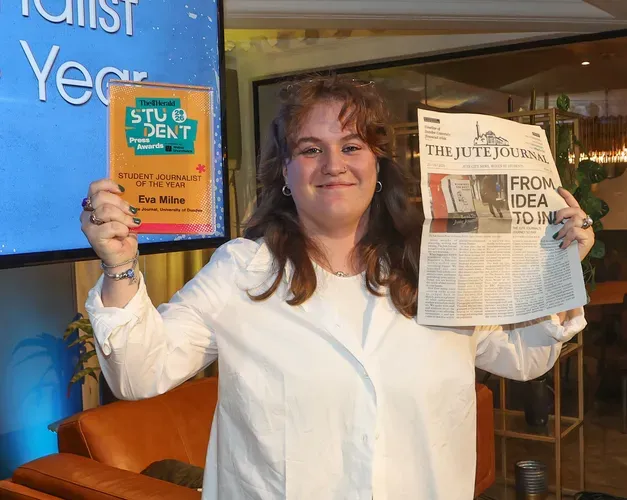 Eva Milne holding a student award and the newspaper The Jute Journal