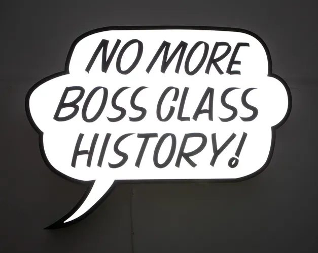 Lightbox sculpture in the shape of a comic speech bubble reading 'no more boss class history!'
