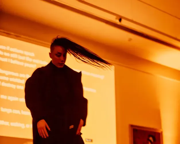 Performer dancing in orange glow of cooper gallery