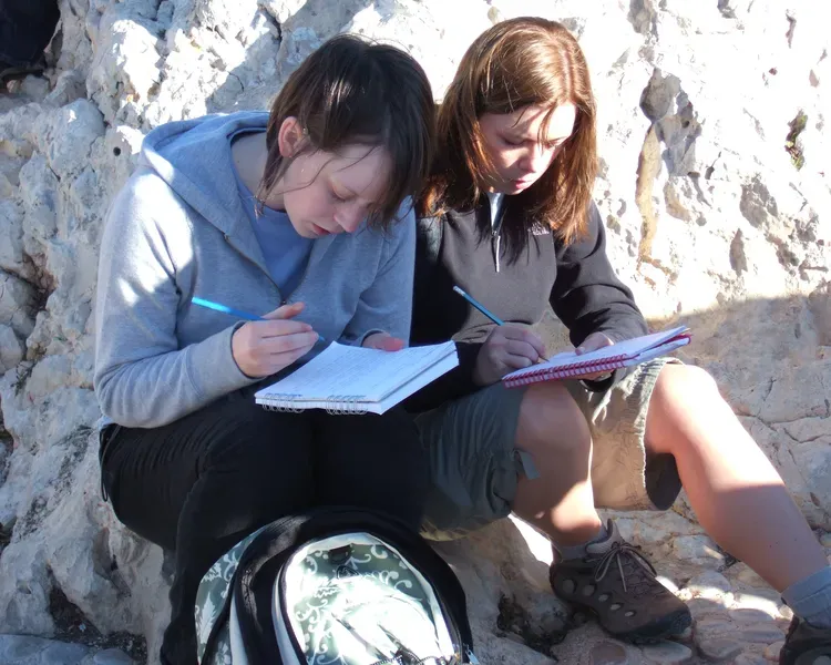 two students writing notes