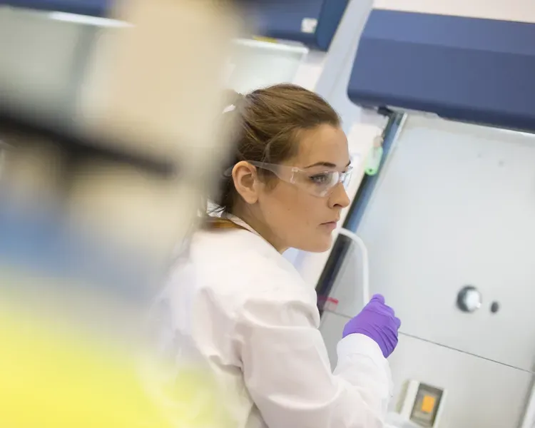 Staff in white coats in a lab