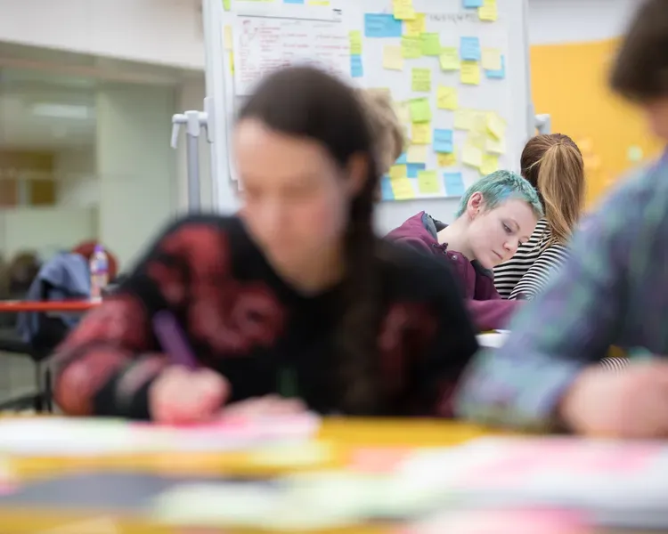 Students working on paper with lots of post it notes