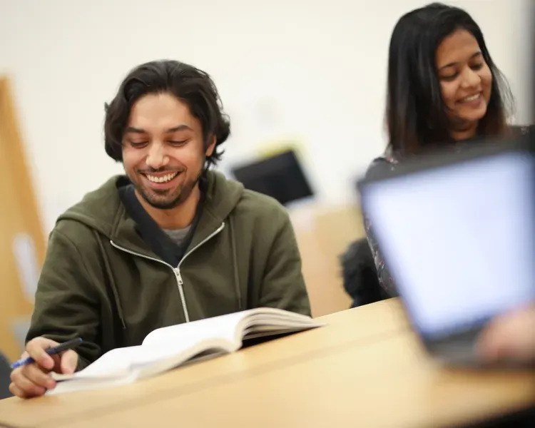 two students smiling and studying