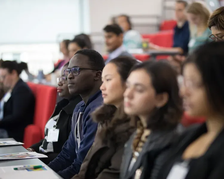 students sitting listening in a lecture theatre 
