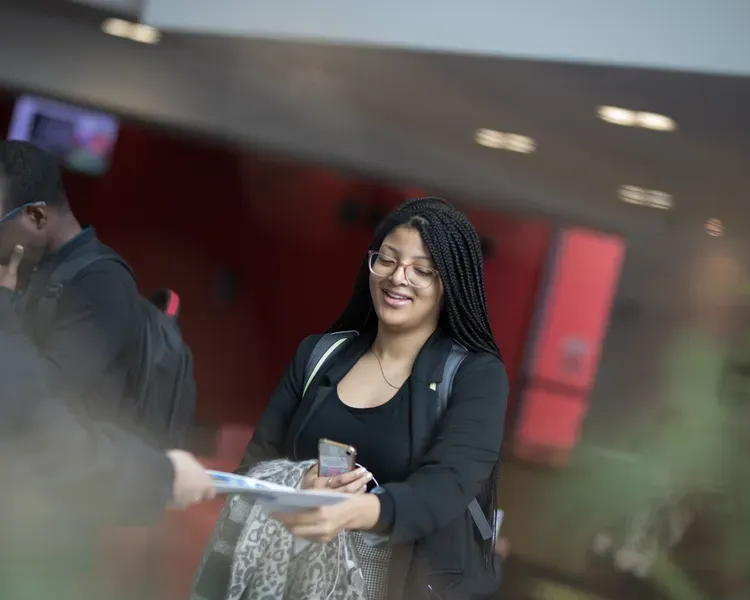 a student being handed a leaflet