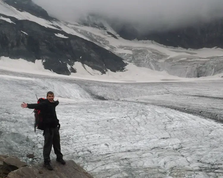 Student standing beside a mountain covered in snow