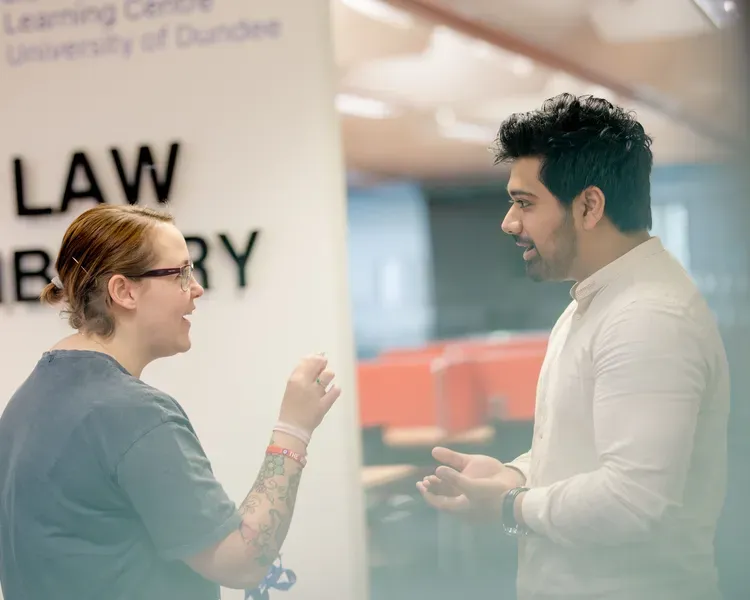 Students standing near Law Library sign