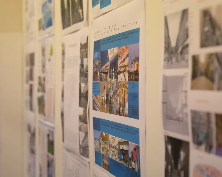 a wall showing printed sheets of urban planning designs