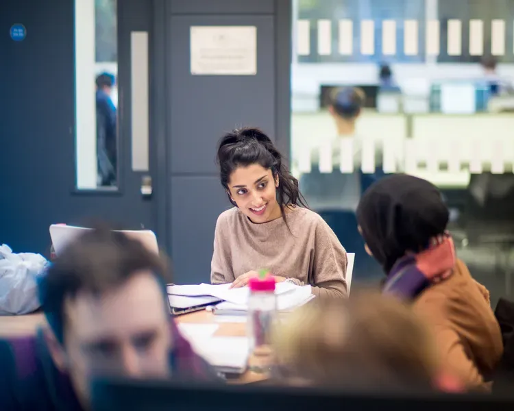 students studying at a table in the library