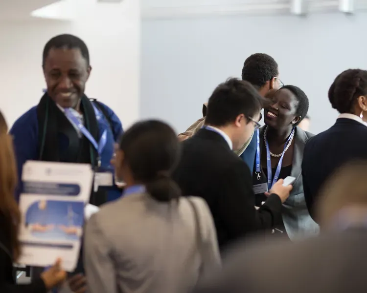 several people chatting and smiling at a conference