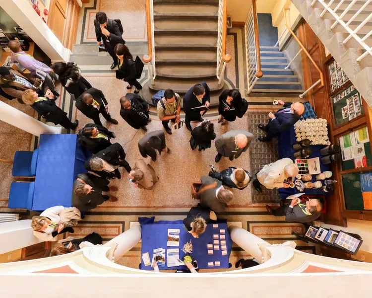 a birdseye view of a group of people at an event in a hallway with stairs
