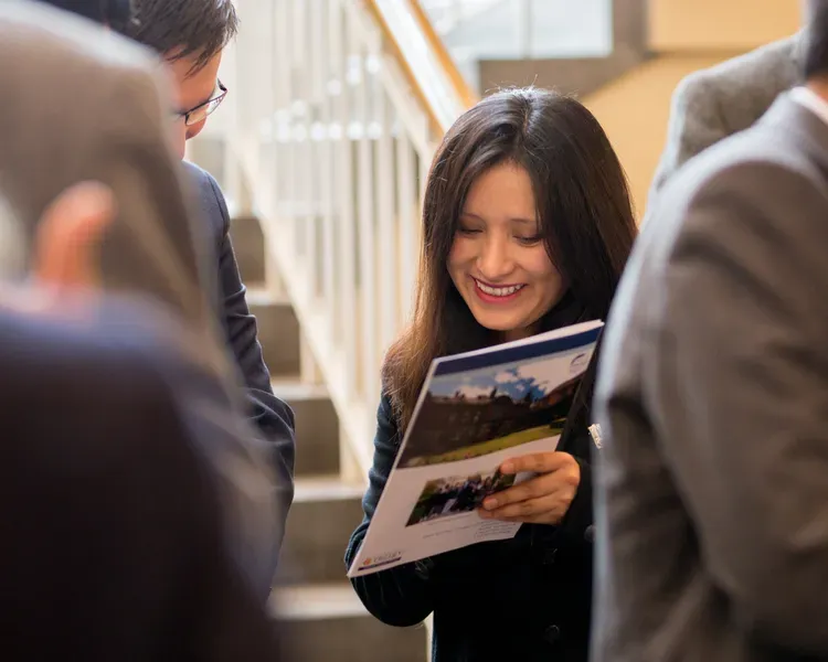 Student showing brochure to a colleague