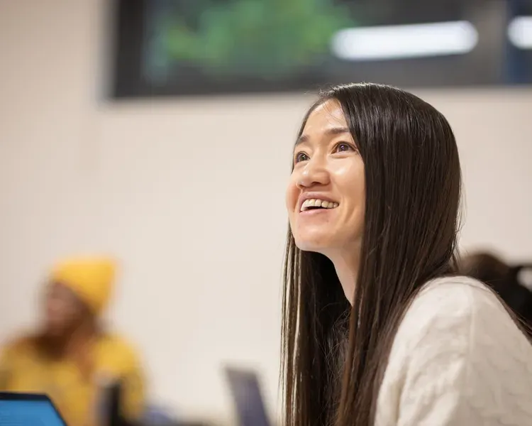 Student looking into the distance with a laptop nearby