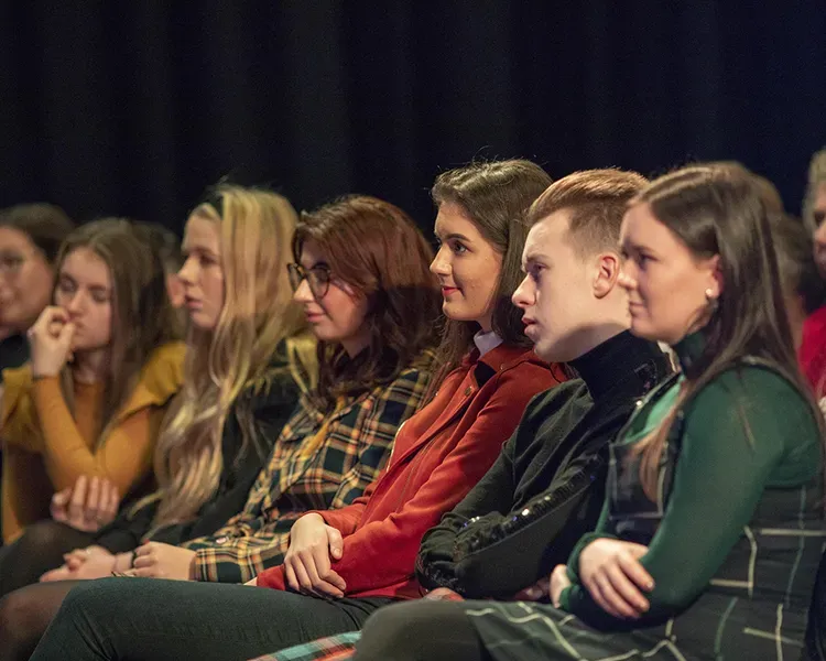 a group of people sitting in chairs watching an event