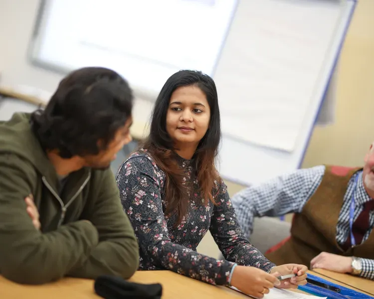 Medical students sitting with member of staff
