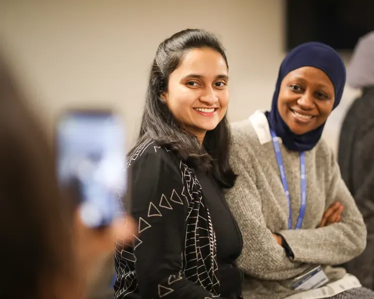 two women standing together at a conference