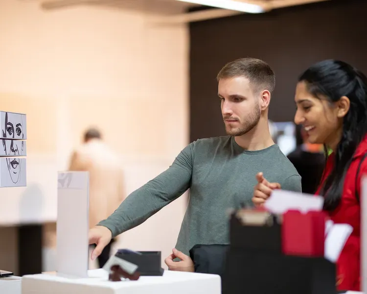 two people looking at a DJCAD degree show exhibit