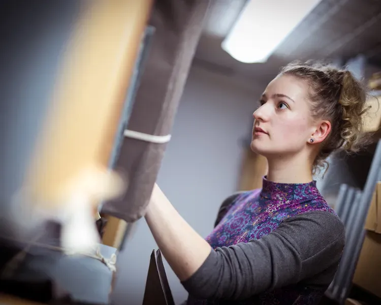young woman in among library archives