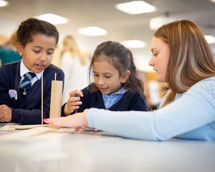 children working together in a school with a student teacher