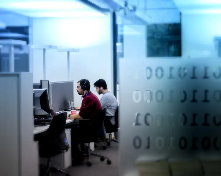 scientists sitting side by site, working on computer screens in a computer lab