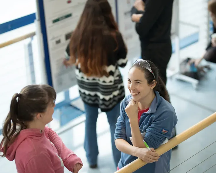 students chatting next to scientific poster display