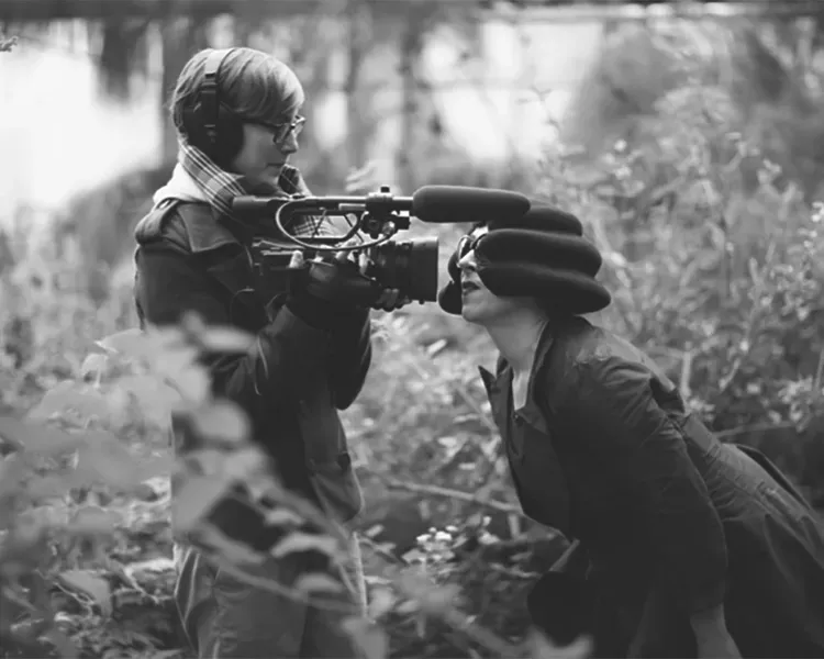 black and white image of two people near a lake