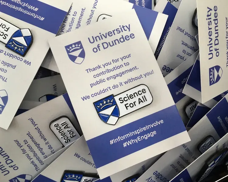 university badges, showing blue university crest pin on a card