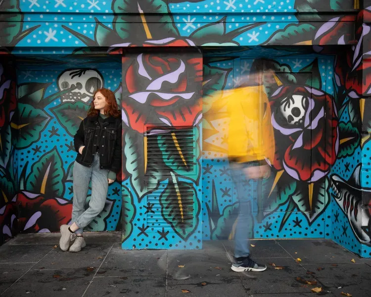 Student standing beside graffiti in Dundee city centre