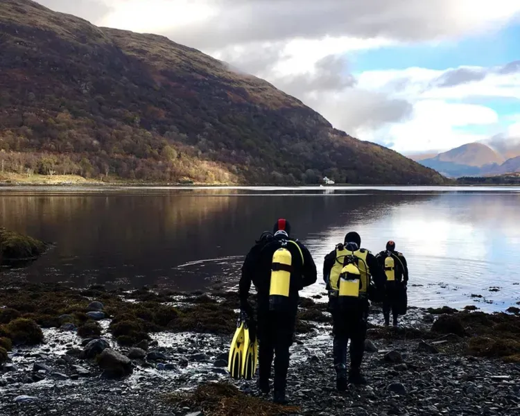 divers standing beside loch