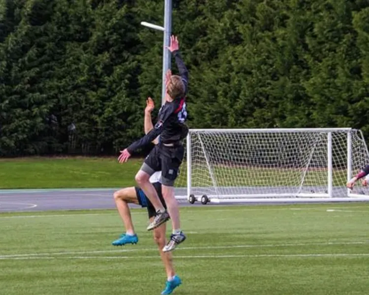 group of people playing frisbee outside