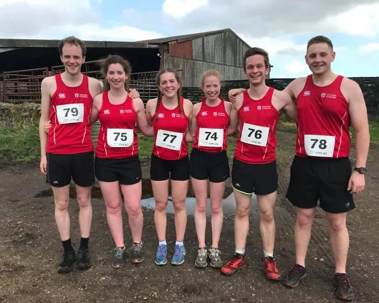 group shot of cross country runners in a muddy field