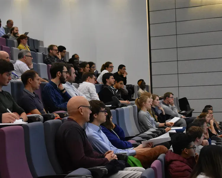 A crowd of people sitting in a lecture hall