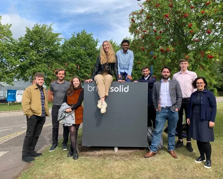 Code Lab team sitting on top of the Bright Solid sign outside the Bright Solid location