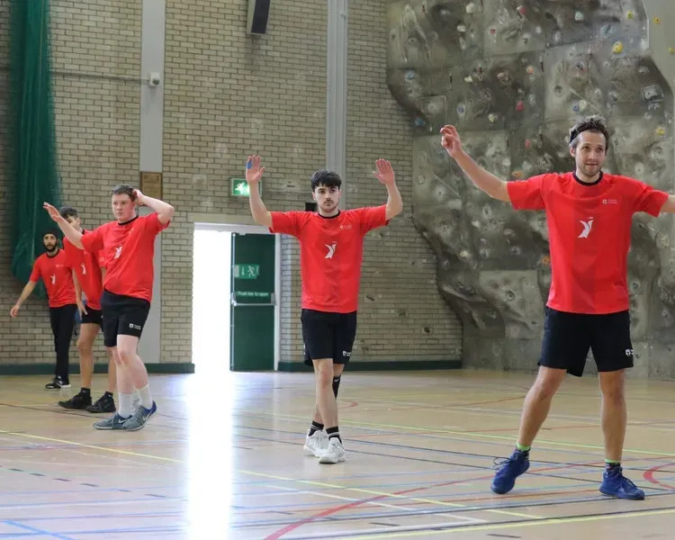 Five participants in red UoD branded tshirts play Handball