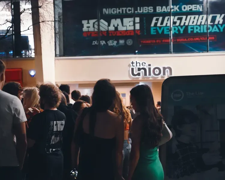 A group of students queue outside of DUSA The Union